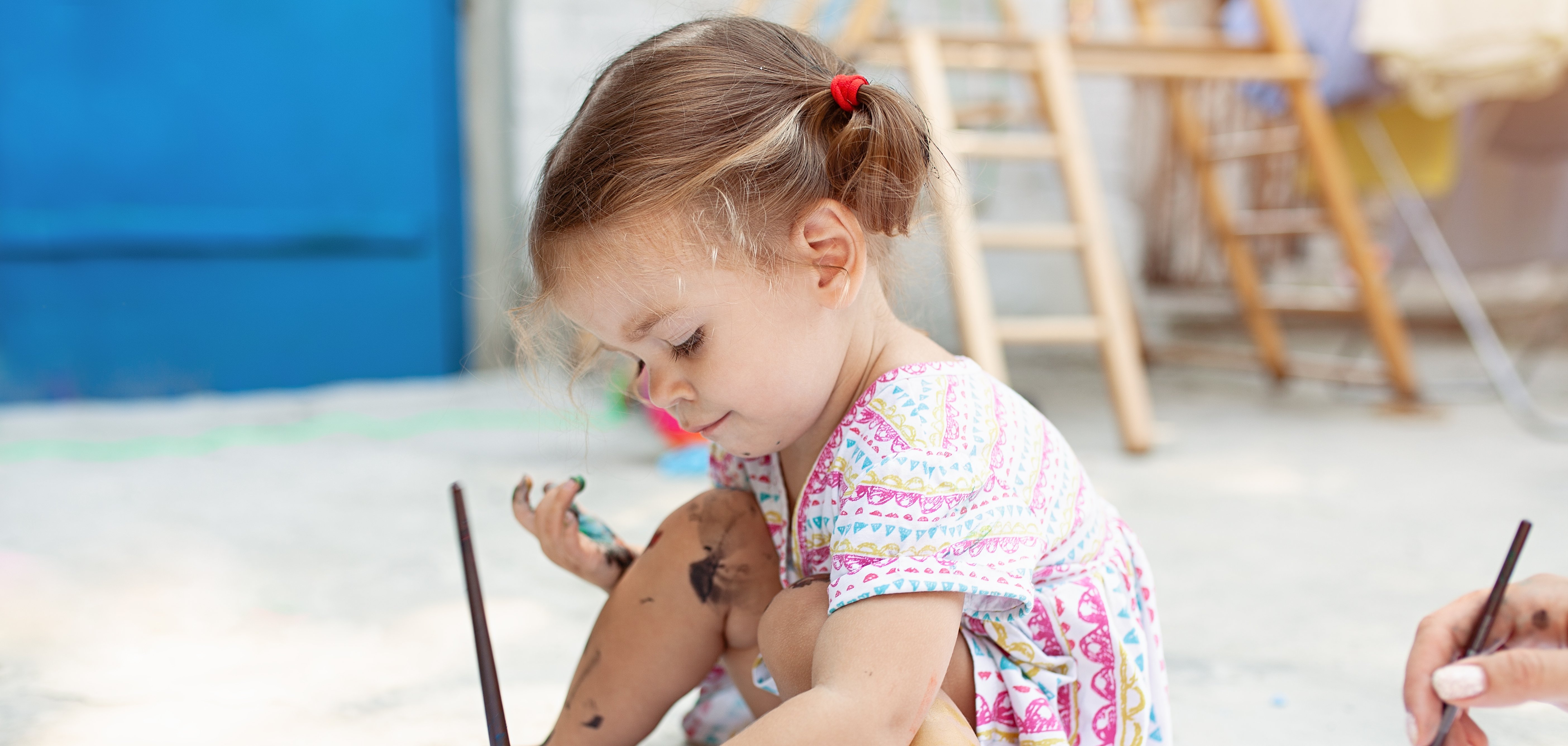 Niedliches kleines Mädchen, das ganz versunken malt.