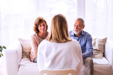 Female doctor talking to a senior couple.