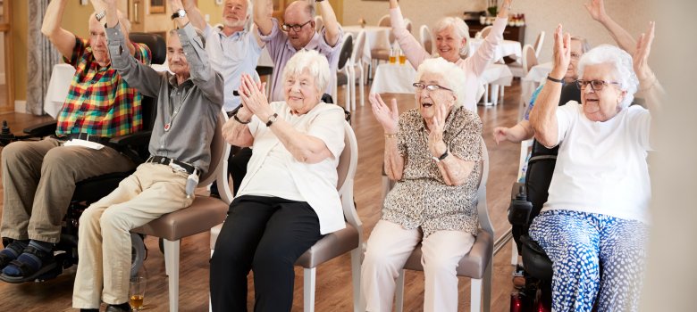 Group Of Seniors Enjoying Fitness Class In Retirement Home