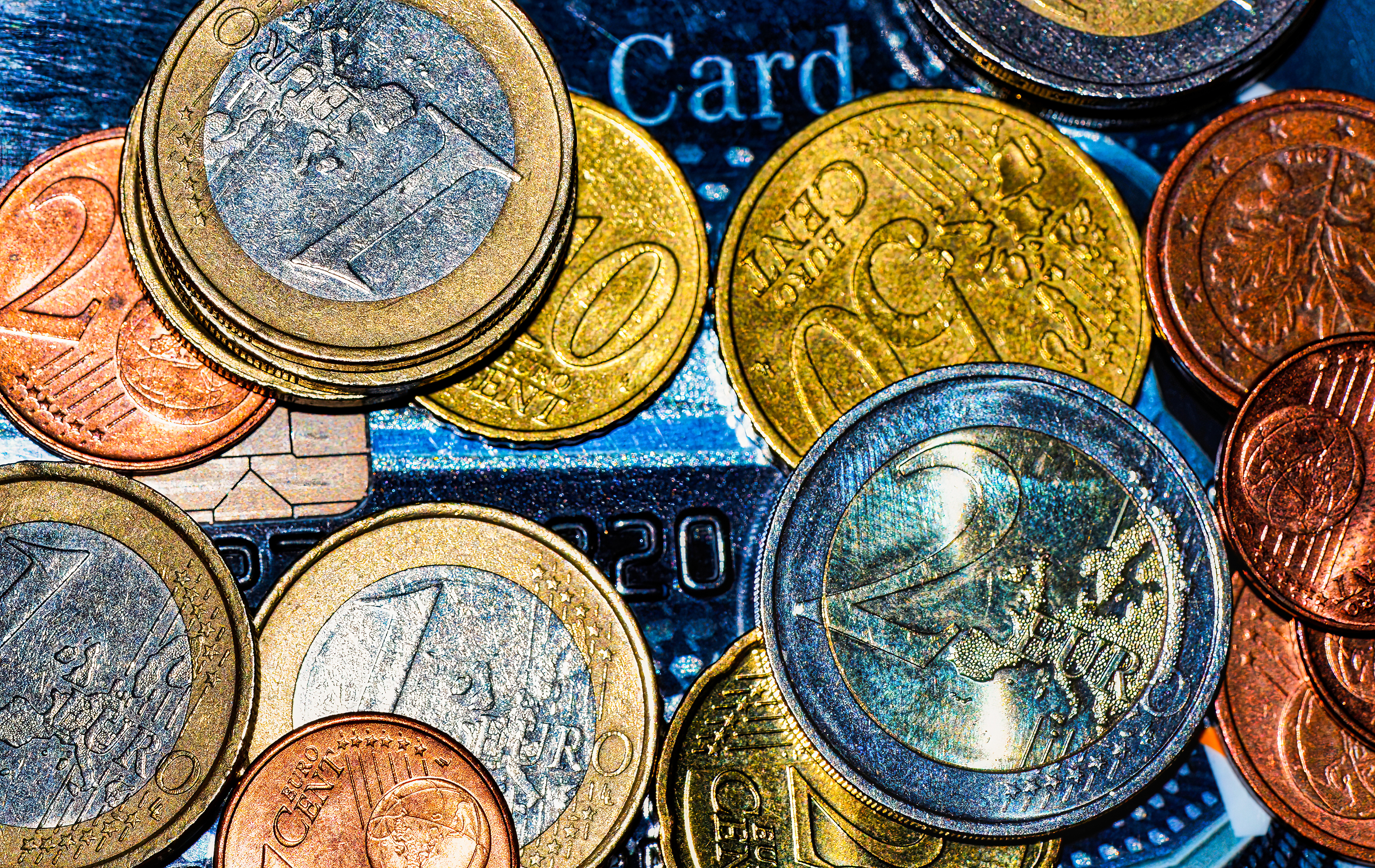 Makroaufnahme von verschiedenen europäischen Münzen, die auf einer Kreditkarte liegen.