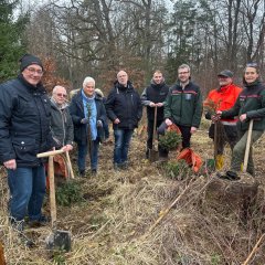 Männer und Frauen mit Spaten in der Hand.
