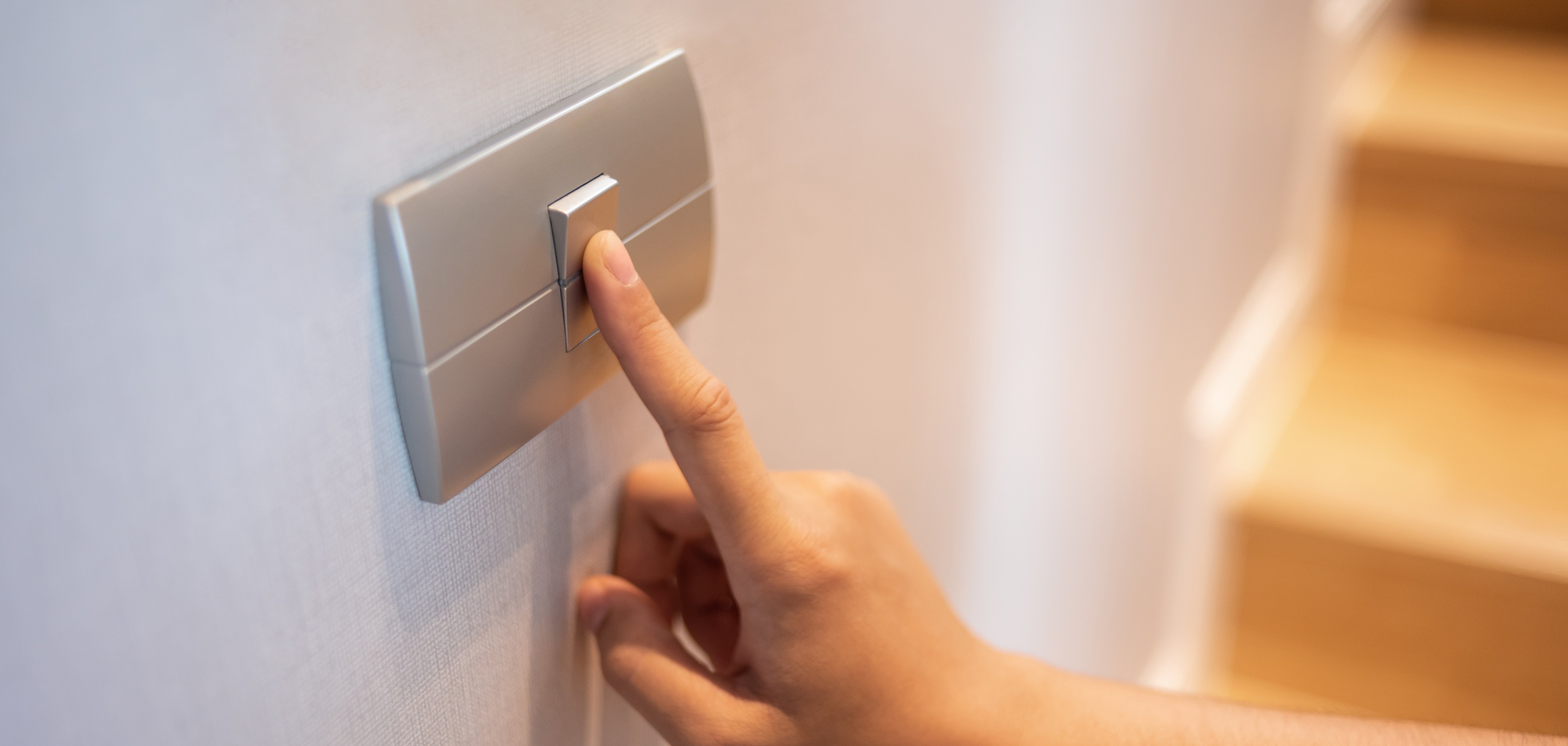 Nahaufnahme eines Fingers, der einen Lichtschalter im Haus ein- oder ausschaltet.