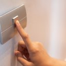 Nahaufnahme eines Fingers, der einen Lichtschalter im Haus ein- oder ausschaltet.