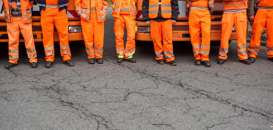Garbage truck drivers standing in front of their vehicles, Germany