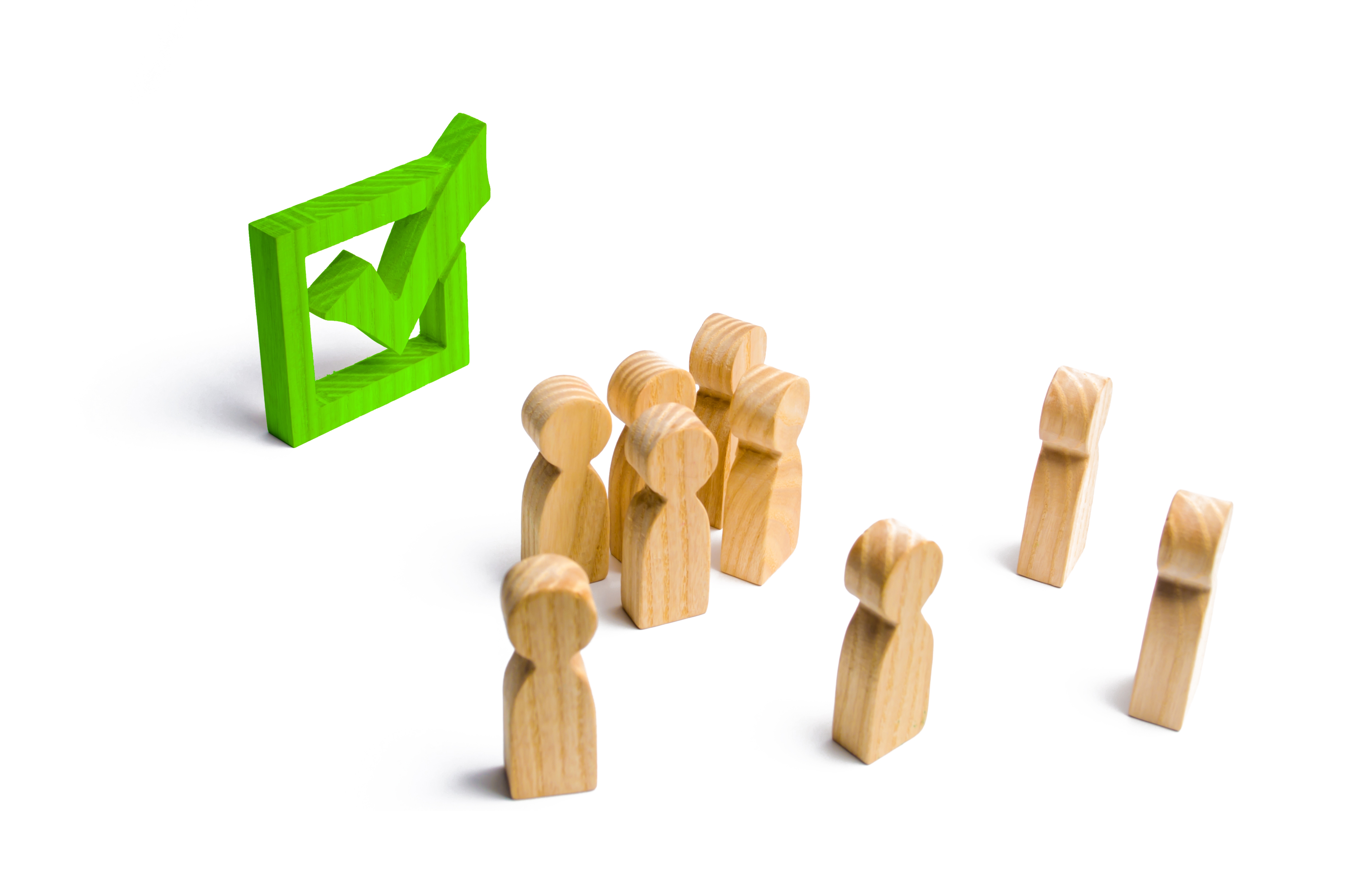 Kleine Holzmännchen bei einer Wahl, einer Abstimmung oder einem Referendum schauen auf ein grünes Häkchen in einer Box. 