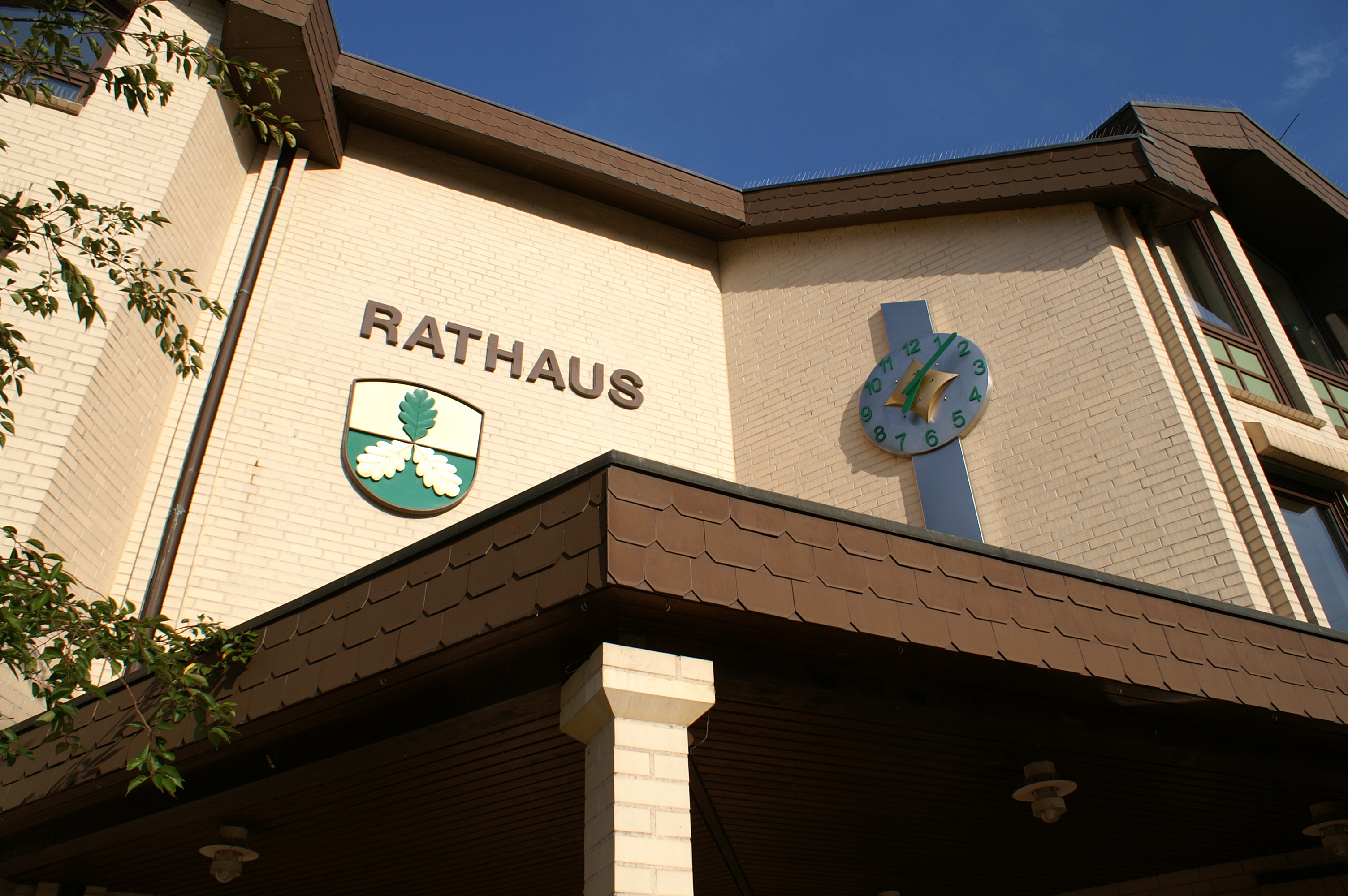 Eingangsbereich des Rathauses Lohfelden mit Wappen und Uhr.
