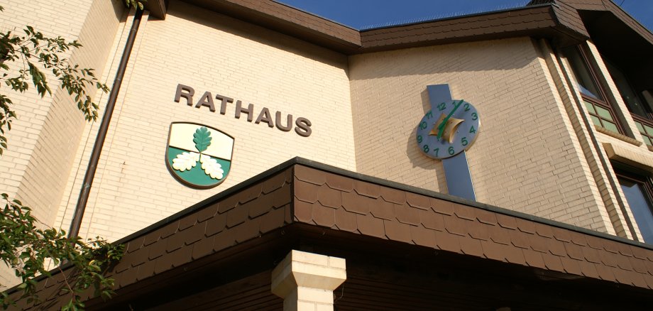 Eingangsbereich des Rathauses Lohfelden mit Wappen und Uhr.
