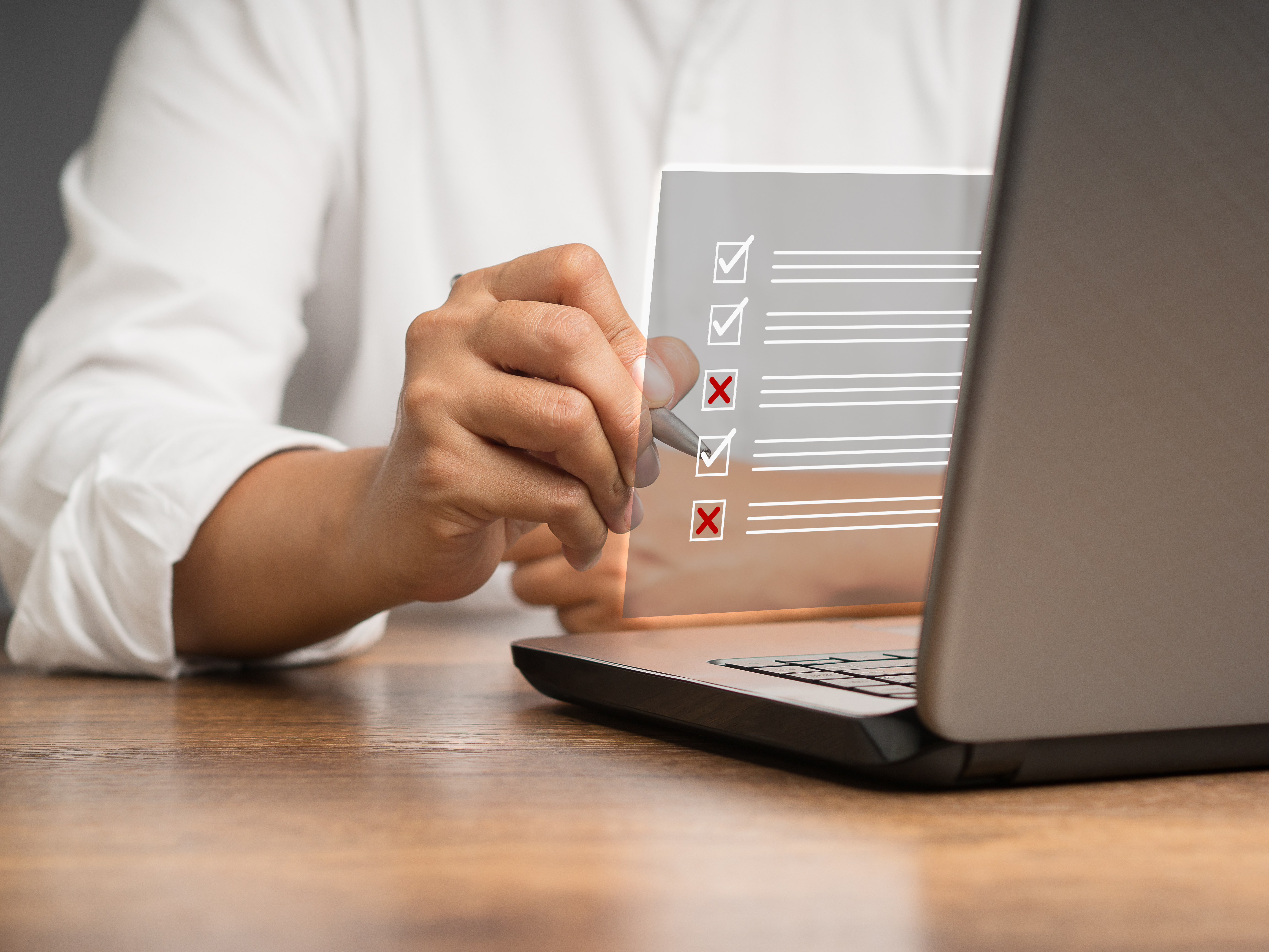 Ein Geschäftsmann macht ein Häkchen und ein Kreuzsymbol auf einem Dokumentenmanagementsystem oder DMS auf einem virtuellen Bildschirm. Bewertungsformular, Fragebogen und Checklistenverwaltung
