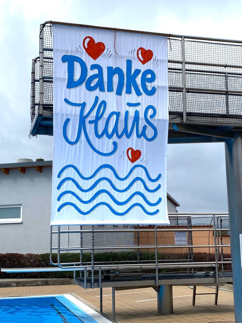 Das Transparent der Dauerschwimmerinnen und Dauerschwimmer, kreiert und gestiftet vom Grafiker Wolfgang Loewe, am Sprungturm.