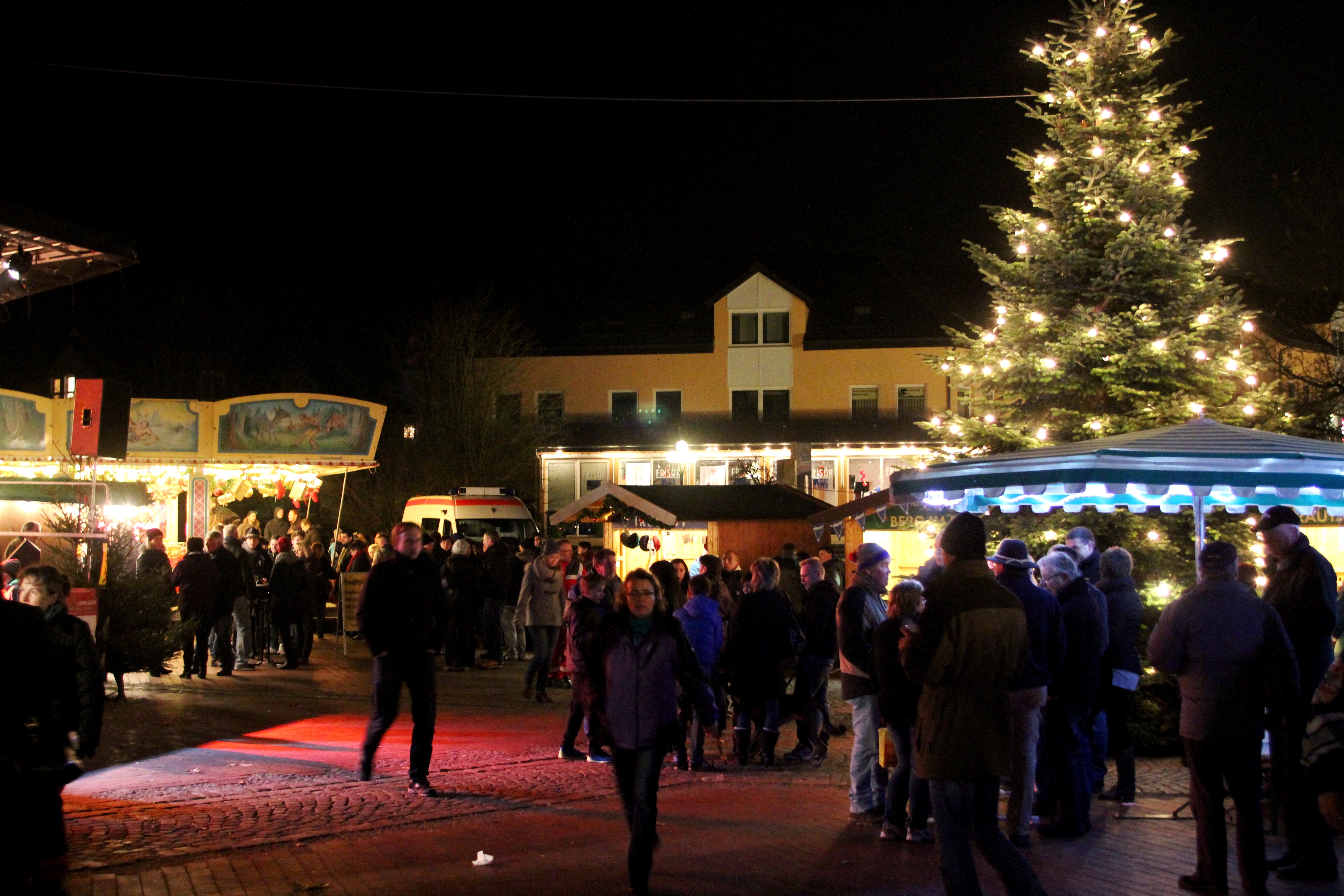Blick auf den Rathausplatz während des Weihnachtsmarkts. Der Weihnachtsbaum strahlt!