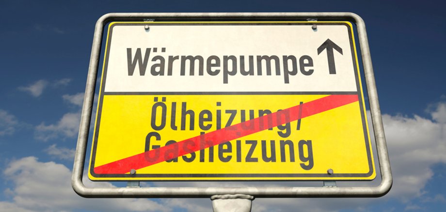 A German place-name sign with the German words "Oel- /Gasheizungen" (Oil and gas heating) and "Waermepumpe" (heat pump) A German place-name sign with the German words "Oel- /Gasheizungen" (Oil and gas heating) and "Waermepumpe" (heat pump)