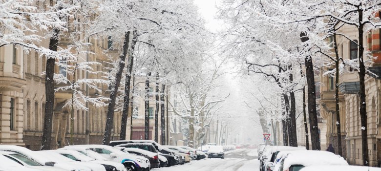 Eine stark verschneite Straße in einem Wohngebiet einer deutschen Stadt.