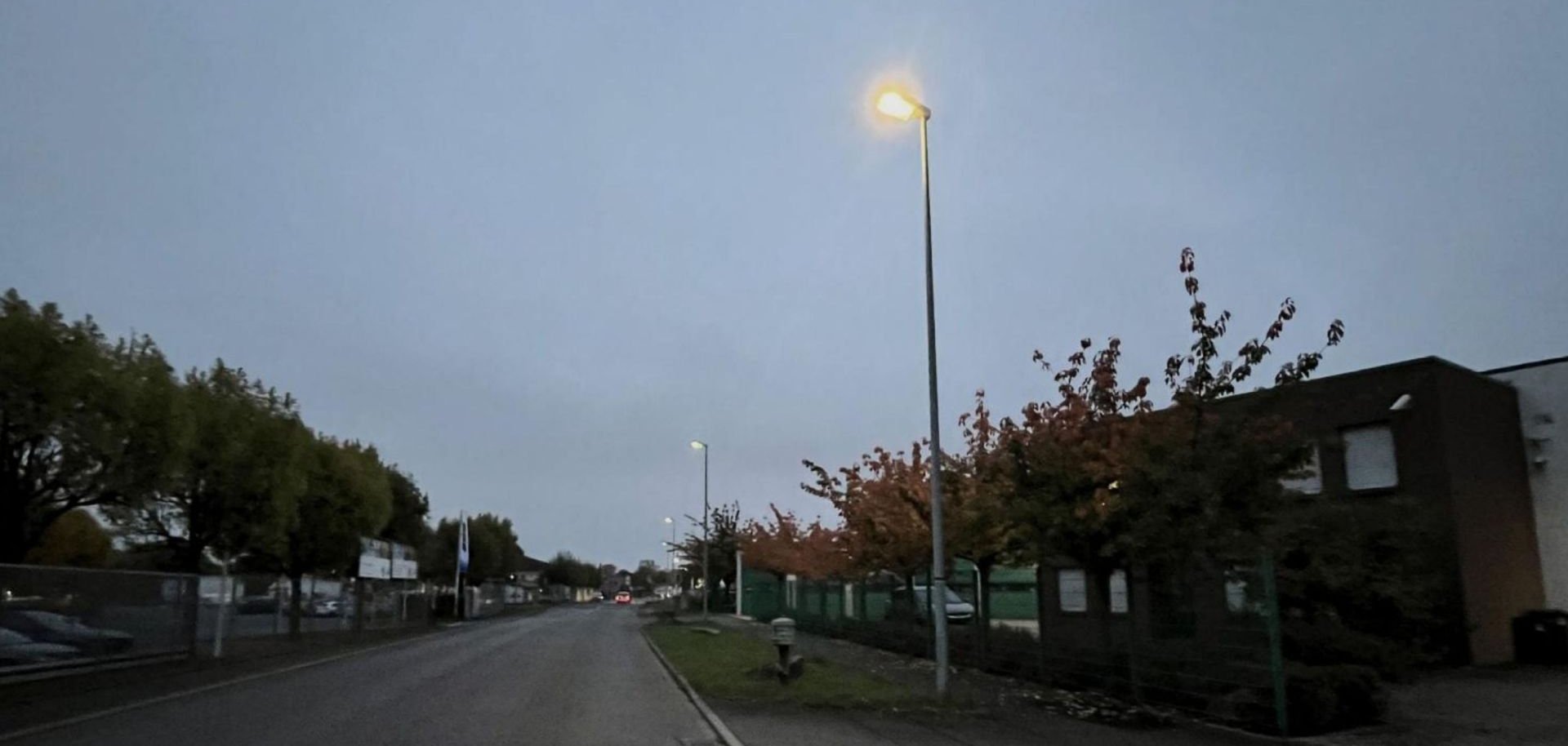 Dunke Straße im Gewerbegebeit mit traditionellen Laternen auf der rechten Seite beleuchtet.